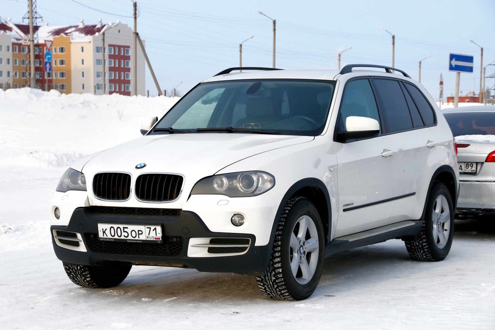 Białe BMW X5 E70 na śniegu.